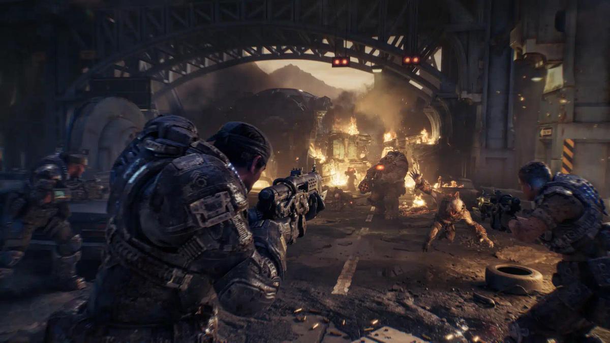 Raskaasti varustetut sotilaat taistelevat hirviöitä vastaan raunioituneessa kaupunkiympäristössä Gears of War: E-Day -pelissä.