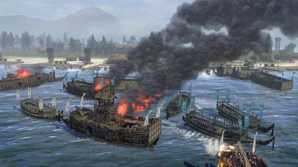 Meritaistelu Total War: Shogun 2 -pelissä, jossa näkyy palavia laivoja ja sotilaita rannikkomaisemassa.